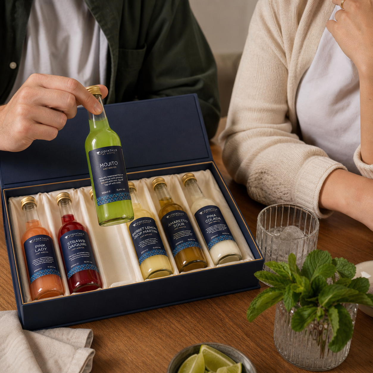 Friends choosing a Mojito bottle from an open cocktail box